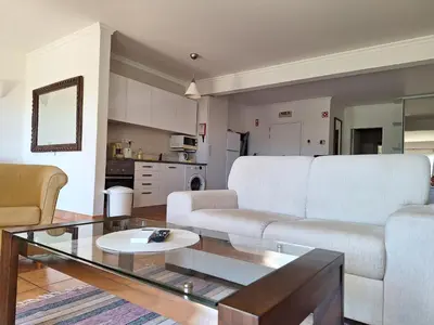 a living room with white furniture and a glass table at Amazing Studio with Ocean View in Lagos