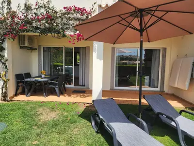 a patio with a table and chairs and an umbrella at Amazing Studio with Ocean View in Lagos