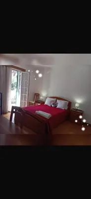 a bedroom with a red bed and a window at House Silvia & Nuno´s in Machico