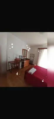 a bedroom with a bed and a table and a window at House Silvia & Nuno´s in Machico