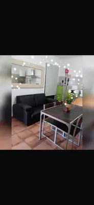 a living room with a table and a black couch at House Silvia & Nuno´s in Machico