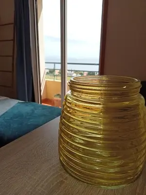 a yellow vase sitting on a table in front of a window at Sunrise Apartment in Caniço
