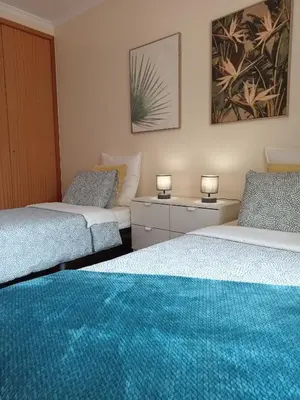 two beds in a room with two lamps on them at Sunrise Apartment in Caniço