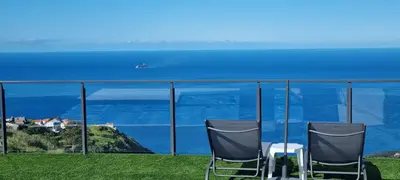 two chairs sitting on a hill overlooking the ocean at Casa Mar Azul in Arco da Calheta