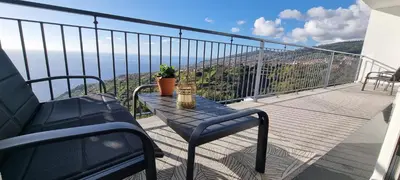 a balcony with a table and chairs on a balcony at Casa Mar Azul in Arco da Calheta