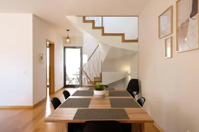 a dining room with a table and a staircase at GuestReady - Charming Caniço Retreat in Caniço