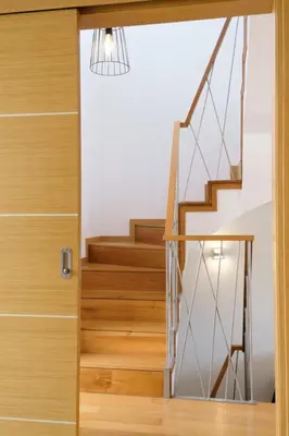 a hallway with a wooden door and stairs at GuestReady - Charming Caniço Retreat in Caniço