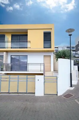 a yellow and white house with a fence in front of it at GuestReady - Charming Caniço Retreat in Caniço