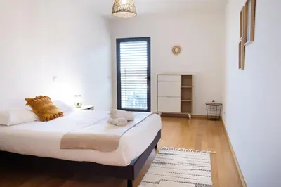 a white bedroom with a large bed and a window at GuestReady - Charming Caniço Retreat in Caniço