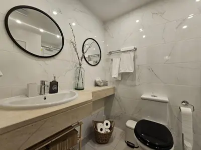 a bathroom with a sink and a toilet and a mirror at A Pérola da Madeira by Rentallido in Funchal