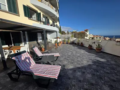 a patio with chairs and tables on a building at A Pérola da Madeira by Rentallido in Funchal