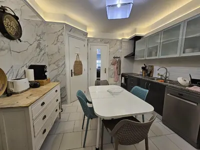 a kitchen with a white table and chairs in it at A Pérola da Madeira by Rentallido in Funchal