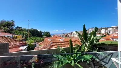 a car parked next to a building on a street at Sol do Til Apartment in Funchal