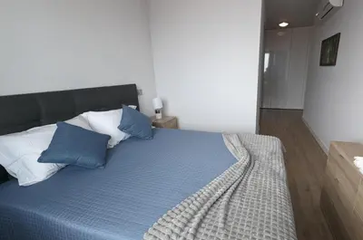 a bedroom with a bed with blue and white pillows at Sol do Til Apartment in Funchal