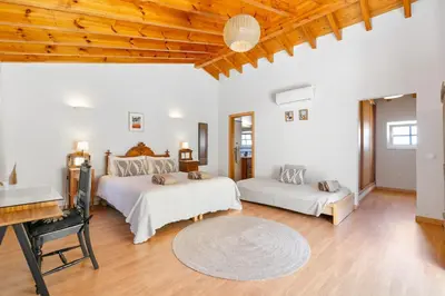 a bedroom with two beds and a desk and a table at Pita's House - Villa Sagres 2 in Sagres
