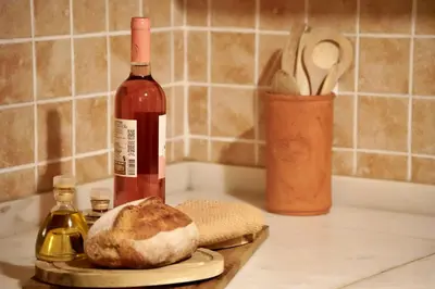 a bottle of wine and a loaf of bread on a counter at Pita's House - Villa Sagres 2 in Sagres