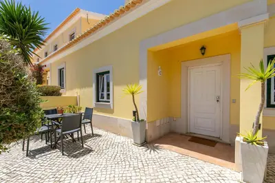 a yellow house with a table and chairs and a door at Pita's House - Villa Sagres 2 in Sagres