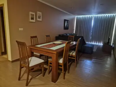 a dining room with a table and chairs and a couch at Ocean Breeze Apartment in São Vicente