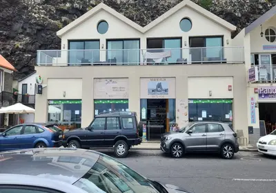 a parking lot with cars parked in front of a building at Ocean Breeze Apartment in São Vicente