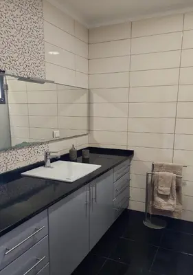 a bathroom with a sink and a mirror at Ocean Breeze Apartment in São Vicente