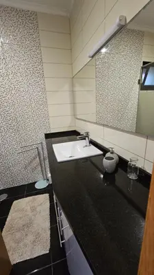 a bathroom with a sink and a mirror at Ocean Breeze Apartment in São Vicente