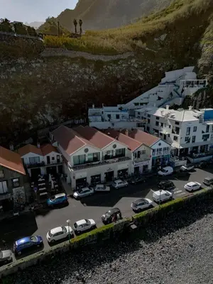 a group of buildings and cars parked in a parking lot at Ocean Breeze Apartment in São Vicente