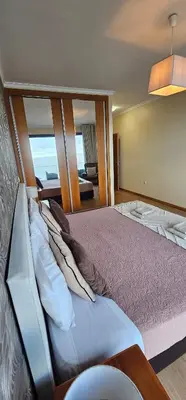 a bedroom with a large bed with pillows at Ocean Breeze Apartment in São Vicente