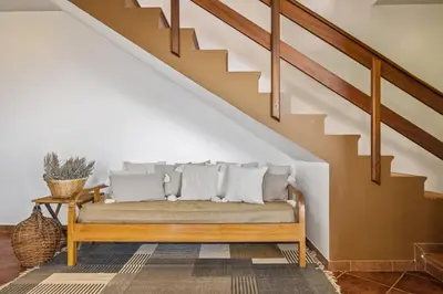 a bench with pillows on it sitting under a staircase at Green Valley by Homie in Porto Moniz