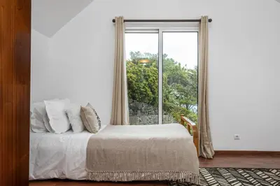 a bedroom with a bed and a large window at Green Valley by Homie in Porto Moniz