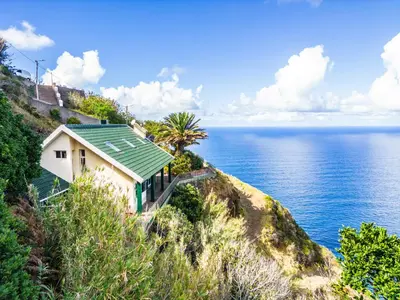 a house on a hill next to the ocean at Green Valley by Homie in Porto Moniz