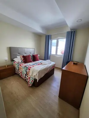 a bedroom with a bed with red pillows and a window at Blue Horizon, Sea and Mountain view in Estreito da Calheta