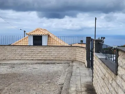 a building with a roof on top of a wall at Blue Horizon, Sea and Mountain view in Estreito da Calheta