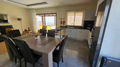 a kitchen and dining room with a wooden table and chairs at Blue Horizon, Sea and Mountain view in Estreito da Calheta