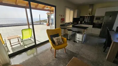 a kitchen with a yellow chair and a table with a view at Blue Horizon, Sea and Mountain view in Estreito da Calheta
