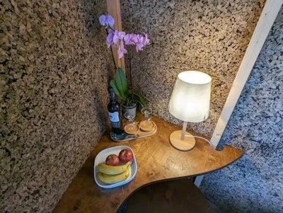 a table with a bowl of fruit and a lamp and flowers at Magical Treehouse in Lagos