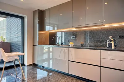 a kitchen with white cabinets and a table and a chair at Becas Place, a Home in Madeira in Funchal
