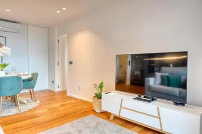 a living room with a large tv on a wall at Becas Place, a Home in Madeira in Funchal
