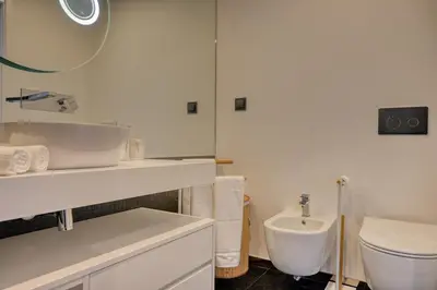 a white bathroom with a sink and a toilet at Becas Place, a Home in Madeira in Funchal