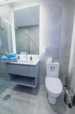 a bathroom with a white toilet and a sink at Vista Oceano IV in Caniço