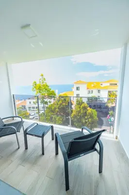 a balcony with two chairs and a view of the ocean at Vista Oceano IV in Caniço