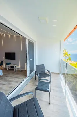 a living room with two chairs and a television at Vista Oceano IV in Caniço