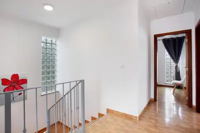 a staircase in a house with a red bow on the wall at Simão House in Calheta