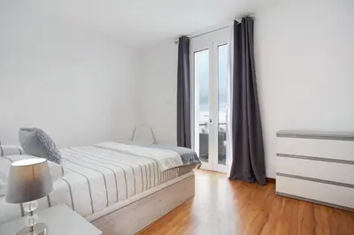 a white bedroom with a bed and a window at Simão House in Calheta