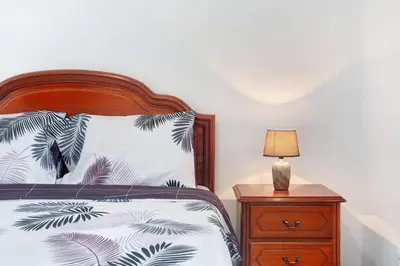 a bedroom with a bed and a nightstand with a lamp at Simão House in Calheta