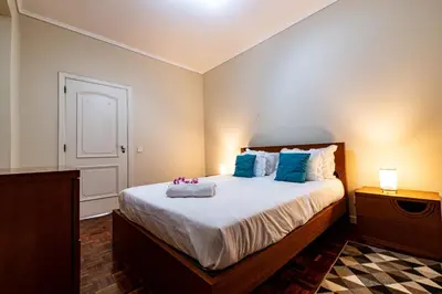 a bedroom with a large bed with blue pillows at GuestReady - Family-Friendly Haven in Funchal in Funchal