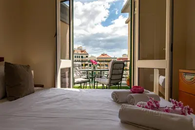 a bedroom with a bed and a view of a balcony at GuestReady - Family-Friendly Haven in Funchal in Funchal