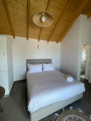 a bedroom with a white bed with a wooden ceiling at Tides proprety - High tide in Paul do Mar