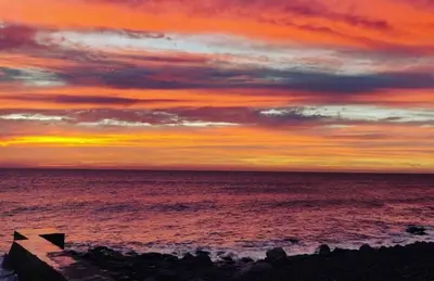 a sunset over the ocean with the sky at Tides proprety - High tide in Paul do Mar