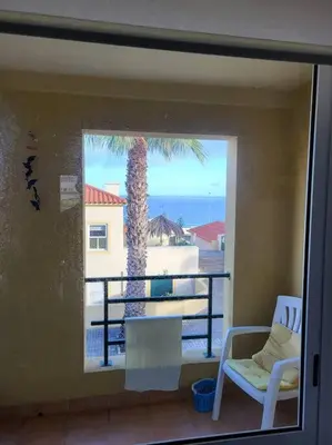 two beds in a white bedroom with a window at Desertrose in Porto Santo