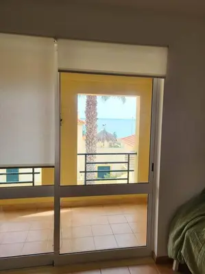 a hallway with white walls and a door with a basket at Desertrose in Porto Santo